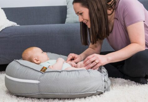 Mother playing with baby in a Podster