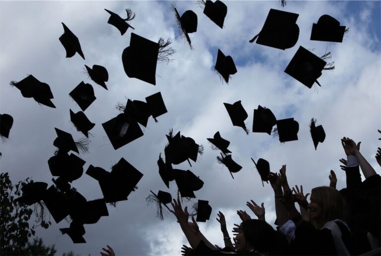 Graduates celebrate, tossing caps in jubilation.
