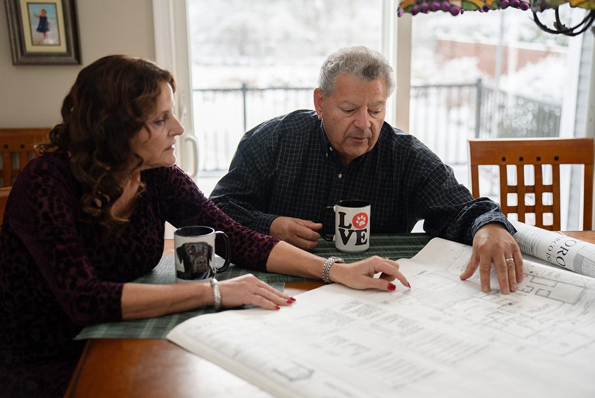 The Santoro family pictured at a kitchen table reviewing building plans.