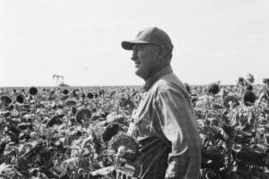 PLF client Cameron Edwards standing in a field looking off into the distance.
